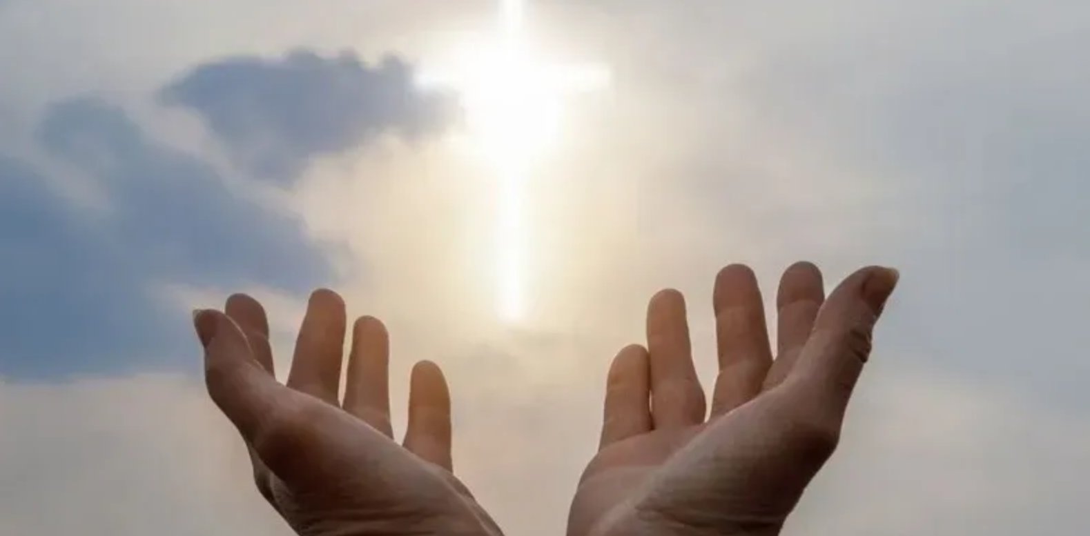 Open hands reaching toward light